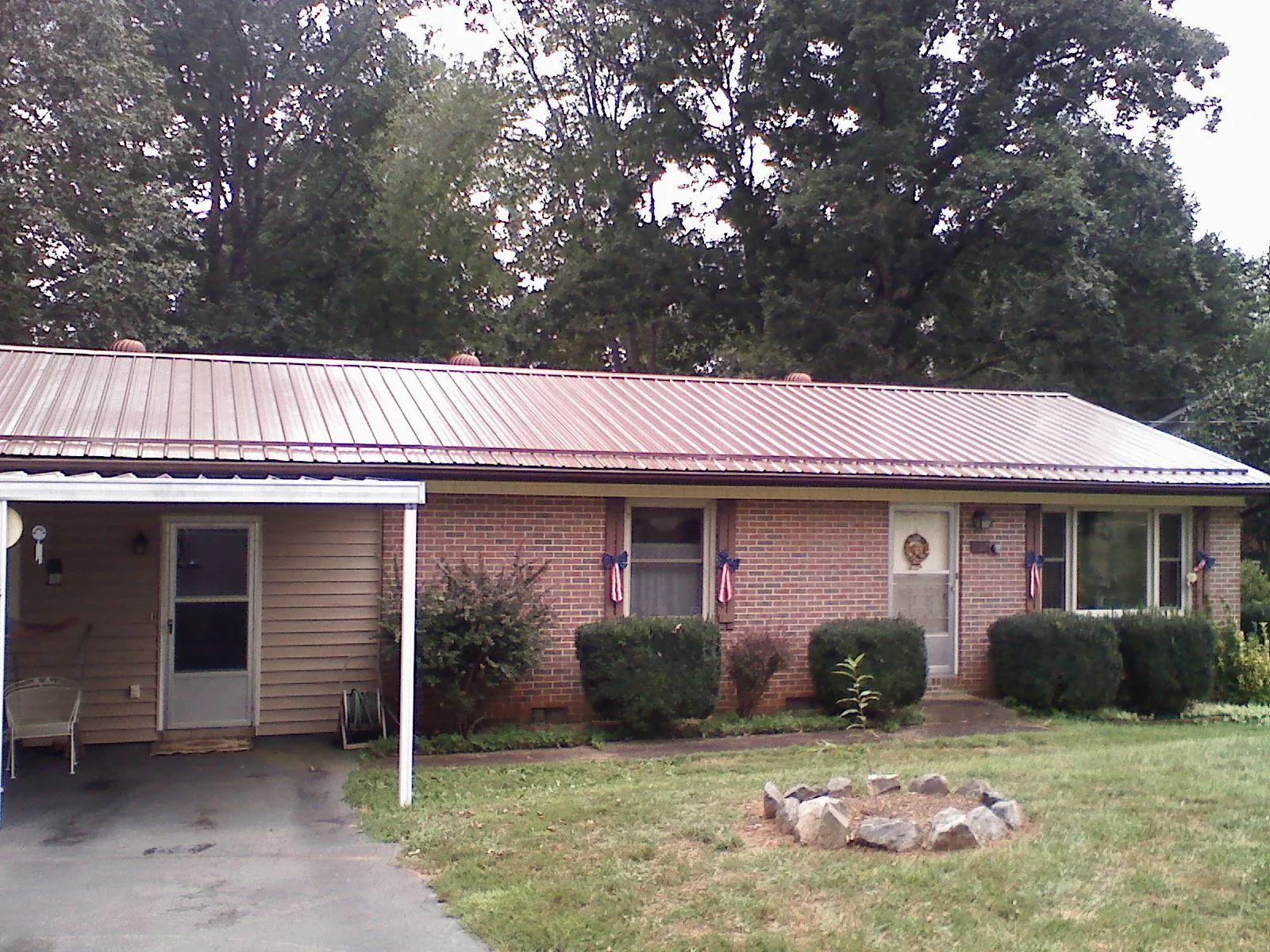 Bronze metal roof and carport on a brick ranch home — Roof Repair work by our crew in Sweetwater